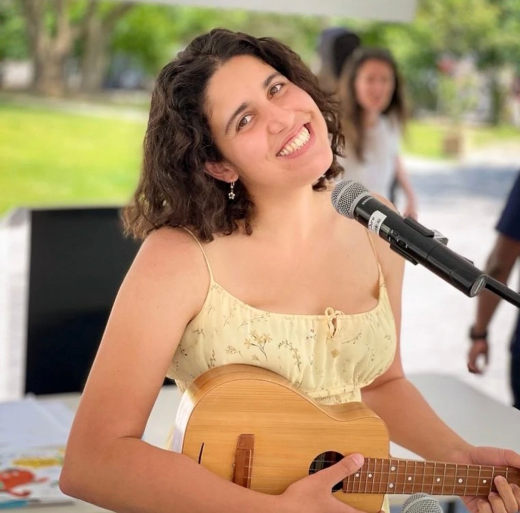 This is a photo of the author Alessandra Requena performing at The Word on the Street festival in Toronto, playing the ukulele
